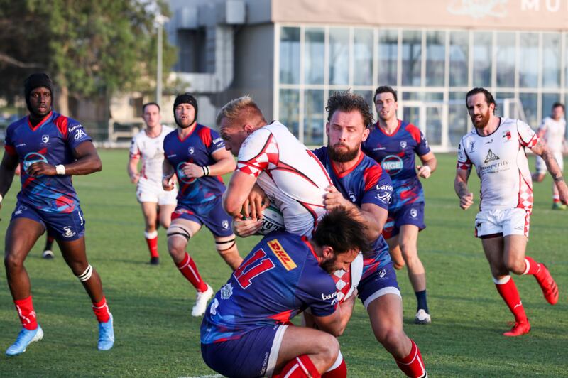 Dave Funston holds on tight as he's tackled. Khushnum Bhandari / The National