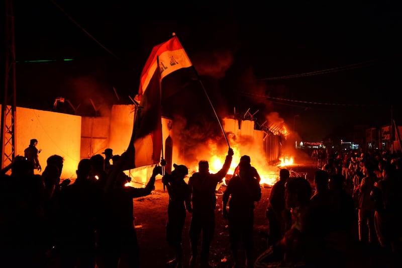 Iraqi demonstrators gather as flames start consuming Iran's consulate in the southern Iraqi Shiite holy city of Najaf on November 27, 2019.  AFP