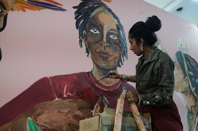 Shilo Shiv Suleman of India, founder of Fearless Collective, paints on a wall during Cop27. Reuters