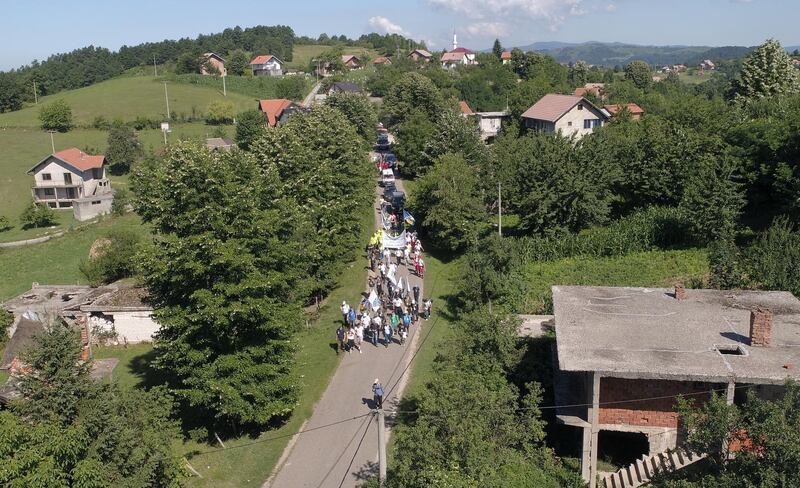 People walk through a forest near the village of Snagovo, Bosnia and Herzegovina, July 8, 2020. Hundreds of people started on Wednesday a 85 km march from Nezuk to Srebrenica called the "March of Peace", to retrace the route in reverse taken by Bosnian Muslims who fled Serb forces as they slaughtered 8,000 of their Muslim kin in 1995. Reuters