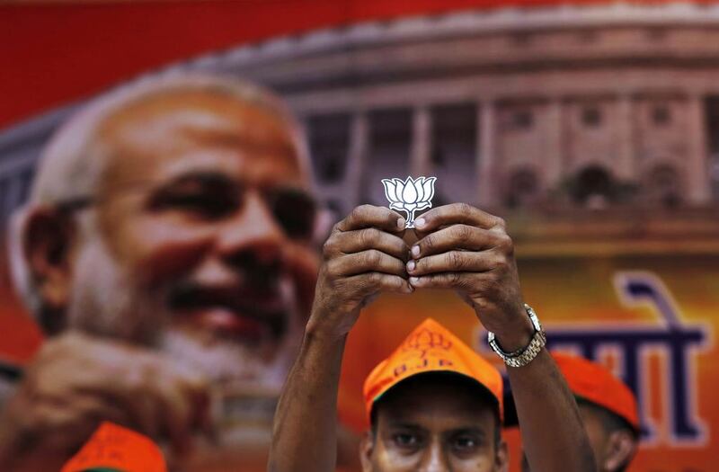 A BJP supporter holds a cut-out of lotus, the election symbol of BJP, during celebrations. Anindito Mukherjee / Reuters / May 16, 2014