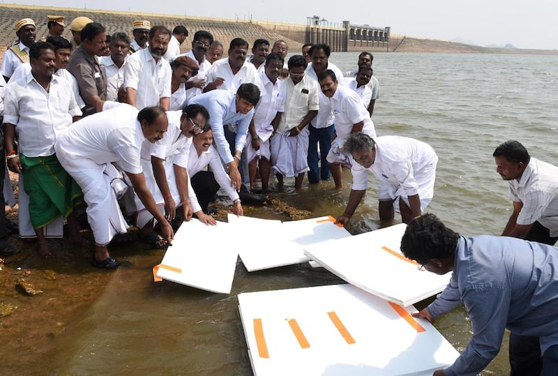 Minister for the Indian state of Tamil Nadu Sellur K Raju, government officials and civic workers use thermocol polystyrene sheets to attempt to cover the reservoir at the Vaigai Dam in Madurai. AFP Photo