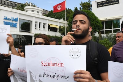 A Tunisian man smokes a cigarette during a demonstration on May 27, 2018 in Tunis to denounce the arrests of non-fasting people and ask for the July 1981 circular, forbidding restaurants and bars owners to open their shops during the fast of the holy month of Ramadan, to be stopped. - The demonstration "Mouch Bessif" ("not against our will"), which is held under the slogan "All for a secular country, all for a better Tunisia", will claim respect for individual freedoms and will recall the civilian character of the State Tunisia and the freedom of conscience guaranteed respectively by Article 2 and Article 6 of the 2014 Constitution. (Photo by FETHI BELAID / AFP)