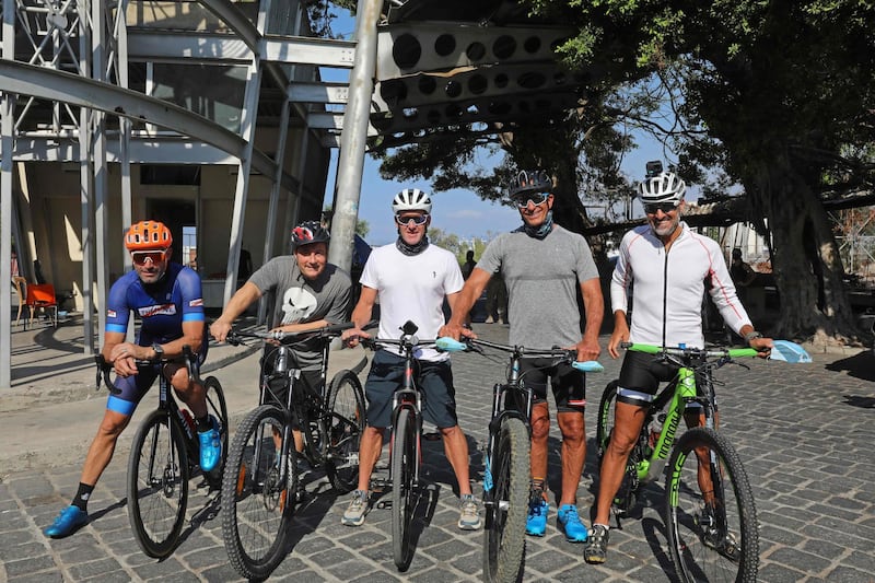 US former professional cyclist Lance Armstrong and Lebanese sportsman Maxime Chaya along with local and foreign cyclists pose for a picture prior to "Bike for Beirut" charity tour at the site of the August 4 port explosion.  AFP