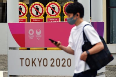 A man wearing a protective mask to help curb the spread of the coronavirus walks past a banner for the Tokyo 2020 Olympic and Paralympic Games on May 11, 2021, in Tokyo. The Japanese government was quick to respond on Tuesday, May 25, 2021 to U.S. travel warning for Americans against traveling to Japan and denied impact on Olympic participants, as the country determinedly prepare to host the postponed games in two months. (AP Photo/Eugene Hoshiko)