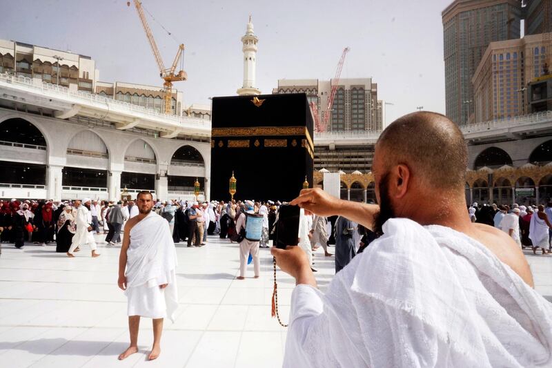 A pilgrim poses for a picture as in front of the Kaaba, the cubic building at the Grand Mosque, during the minor pilgrimage, known as Umrah, in the Muslim holy city of Mecca, Saudi Arabia. At Islam’s holiest site in Mecca, restrictions put in place by Saudi Arabia to halt the spread of the new coronavirus saw far smaller crowds than usual on Monday. AP Photo