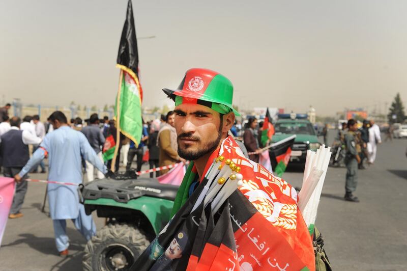 A vendor who sells flag poses for a photograph during a gathering of civil society activists urging the government to secure Ghazni province in downtown Kabul, Afghanistan. Jawad Jalali/EPA