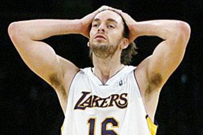 Pau Gasol holds his head as foam hands thrown by Lakers fans are cleared from the court.