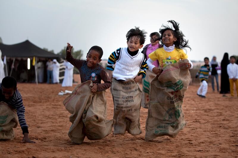 Al Ain, United Arab Emirates, January 30, 2013: 
(L-R) Jasim Eisa, 7, Badr Hamdan, 8, and Nadila Saleh, 7, try their skill and strength in sack jumping as they partake in a Family Day organized for the employees and the foster families of Dar Zayed for Family Care, a state-funded  programme in Al Ain for abandoned, orphaned or neglected children, on Wednesday evening, Jan. 30, 2013, at the Al Bedaa Resort near Al Ain where the organization is based. The children attending Family Day were a mixture of staff children, children who live in Dar Zayed villas and children placed long-term with outside foster families. It is the second time Dar Zayed has held the Family Day event.
Silvia Razgova / The National
