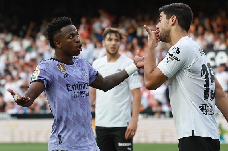 Real Madrid's Brazilian forward Vinicius Junior talks to Valencia's Turkish defender Cenk Ozkacar as he reacts to being insulted from the stands. AFP