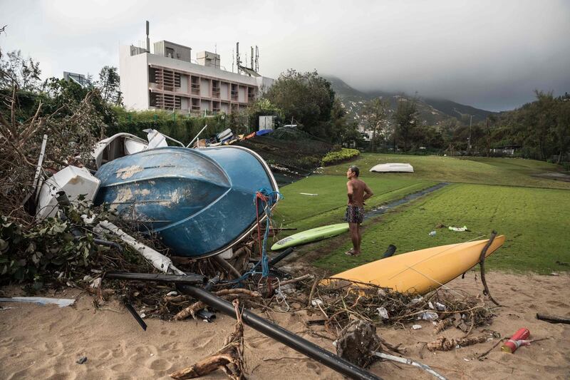 A man looks at damaged boats washed up on a golf course in the aftermath of Typhoon Mangkhut in the coastal village of Shek O in Hong Kong. Dale De La Ray/AFP