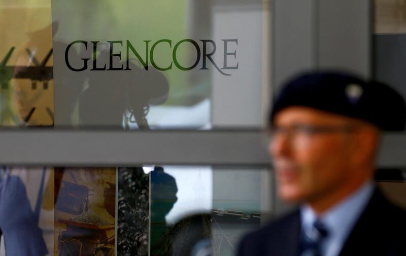 FILE PHOTO: An employee of a private security company stands in front of the logo of commodities trader Glencore during the company's annual shareholder meeting in Cham, Switzerland May 24, 2017. REUTERS/Arnd Wiegmann/File Photo
