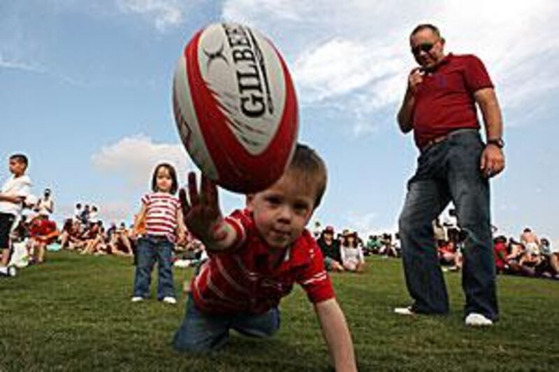 Two-year-old Ewan Fryer enjoys  the first day of the Dubai Rugby Sevens yesterday. A tournament older than the country itself.
