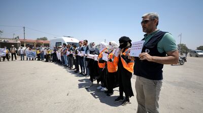 Activists and workers from civil society, humanitarian and medical aid organisations call on the international community to maintain the cross-border humanitarian corridor, at the Bab Al Hawa border crossing, in Idlib, Syria, on July 7. EPA