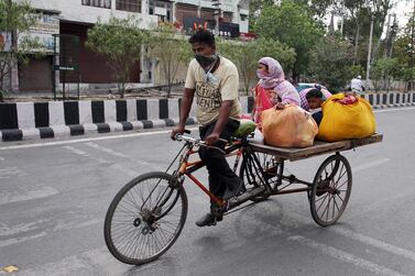 A migrant worker along with his family members rides on a cart, amid the ongoing Covid-19 coronavirus emergency lockdown in India. The government on Tuesday announced a $266bn stimulus package to support the country's economy. EPA