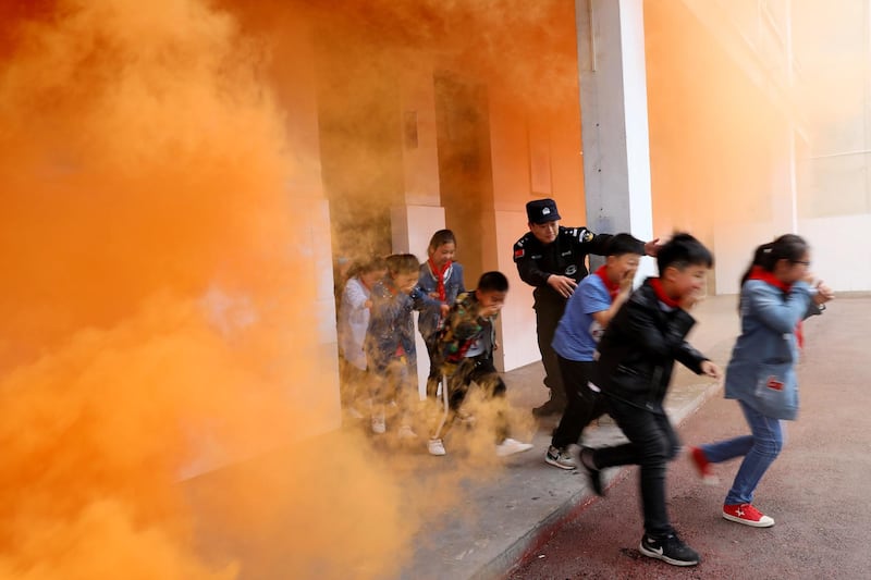 A police officer and school children take part in an anti-terrorism drill at a primary school in Huaibei, Anhui province, China. Reuters