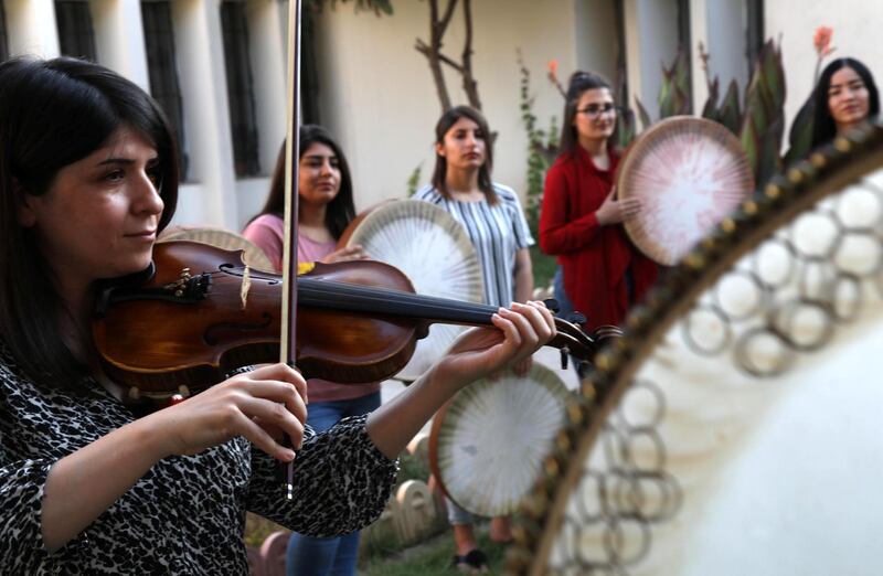 Young Yazidi and Muslim women, part of the musical group "40 Plaits," rehearse a traditional Kurdish song accompanied by the Daf, a large Kurdish frame drum, in a community centre in Dahuk, about 260 miles (430 kilometers) northwest of the Iraqi capital Baghdad, on June 25, 2019. (Photo by SAFIN HAMED / AFP)