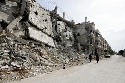 Syrian women walk past destruction in the Baba Amr neighbourhood of Homs in 2012. AFP