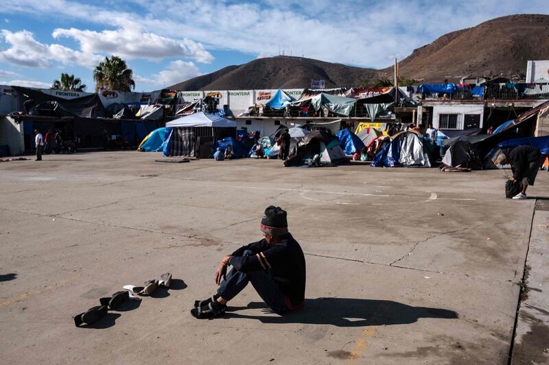 A migrant dries his shoes at a new temporary shelter east Tijuana, Baja California State, Mexico. AFP