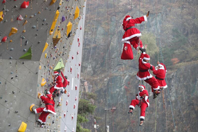 epa08036514 Members of a mountain climbing club, clad in Santa Claus costumes, stage a performance during a ceremony launching the Salvation Army's charity pot campaign in Seoul, South Korea, 01 December 2019.  EPA/YONHAP SOUTH KOREA OUT