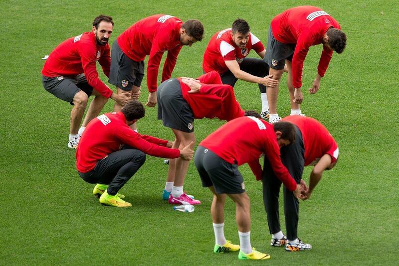 David Villa, second right, of Atletico Madrid streches with Koke, far right, in company of his teammates Juanfran, left, and Gabi Fernandez, second left, during the training session held on Monday in anticipation of the Champions League final on Saturday. Gonzalo Arroyo Moreno / Getty Images / May 19, 2014