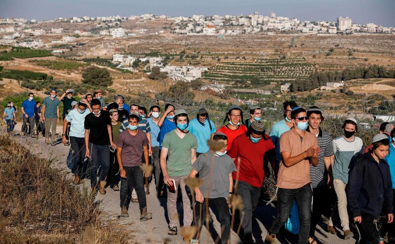 Israeli settlers gather on a hill next to the Palestinian town of Halhul, north of Hebron in the occupied West Bank, as they attend a rally against US President Donald Trump's peace plan. AFP