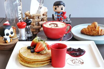 A breakfast selection, including New Avengers mixed berries pancakes and Superman's face on a cup of coffee 