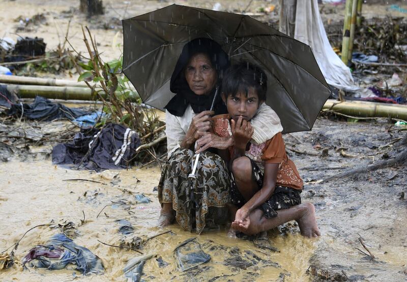 Rohingya refugees take shelter under an umbrella in Bangladesh's Balukhali refugee camp. Dominique Faget / AFP Photo