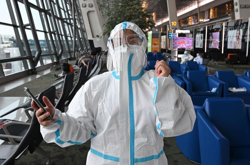 A Chinese passenger, bounds for Shenzhen, China, puts ona personal protective equipments (PPE) against Covid-19 coronavirus before queuing to get on a plane at the Sukarno Hatta international airport in Tangerang on June 8, 2021. / AFP / ADEK BERRY
