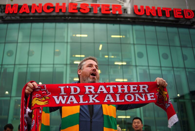 A man sells scarves outside the Old Trafford ground. PA