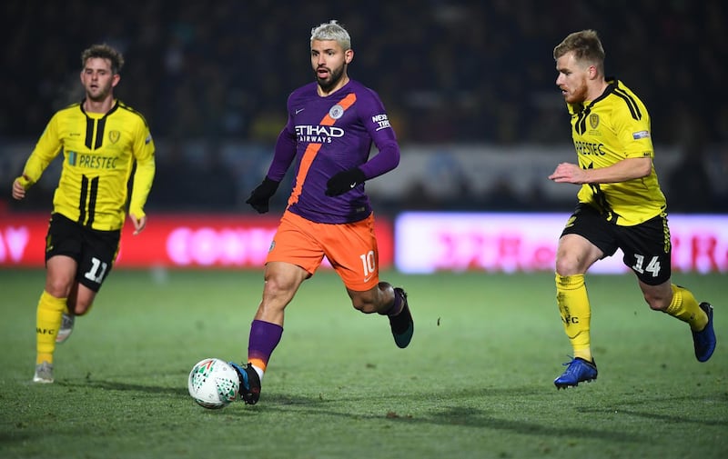 BURTON-UPON-TRENT, ENGLAND - JANUARY 23:  Sergio Aguero of Manchester City battles for possession with Damien McCrory of Burton Albion during the Carabao Cup Semi Final Second Leg match between Burton Albion and Manchester City at Pirelli Stadium on January 23, 2019 in Burton-upon-Trent, United Kingdom.  (Photo by Clive Mason/Getty Images)