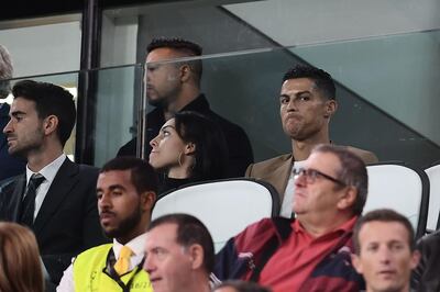 TOPSHOT - Suspended Juventus' Portuguese forward Cristiano Ronaldo (R) and his girlfriend Spanish model Georgina Rodriguez (C) watch the UEFA Champions League group H football match between Juventus and Young Boys from the tribune, on October 2, 2018 at the Juventus stadium in Turin.  / AFP / Marco BERTORELLO
