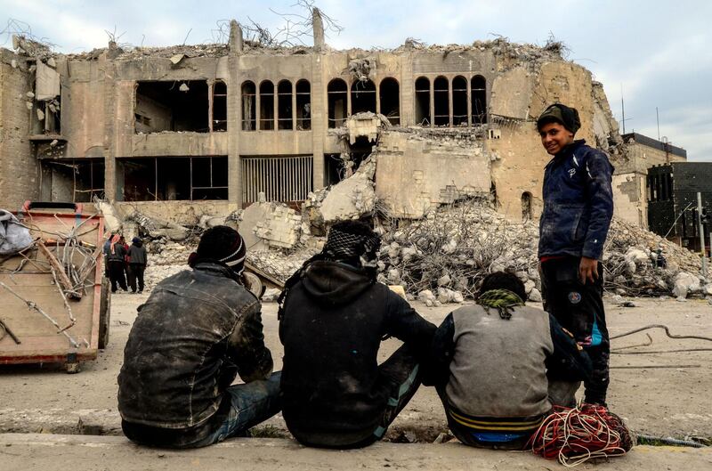 Iraqis scavenge for metal from the rubble of the destroyed seven-storey Chadirji Building, designed by celebrated Iraqi architect Rifat Chadirji in the 1960s, on January 13, 2019, in the city of Mosul. Authorities in Mosul have begun demolishing a onetime icon of modern Iraqi architecture used by the Islamic State group to throw men accused of being gay to their deaths. Labourers in the city's west could be seen removing rubble and twisted metal from the gutted ruins of the National Insurance Company (NIC). The building was heavily damaged in the months-long fight to oust Islamic State (IS) from Mosul, which ended in the summer of 2017. 
 / AFP / Zaid AL-OBEIDI
