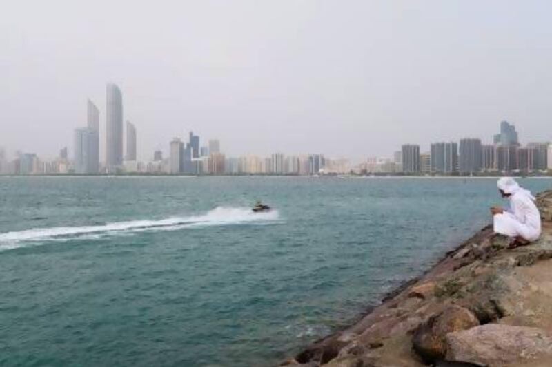 A jet ski motors past the breakwater with Abu Dhabi skyline in the background. They are being banned from some areas and tighter controls are being brought in to improve safety for other water users. Duncan Chard / Bloomberg