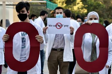 A medical student at the American University of Beirut carries a placard during a protest against the adjustment of the dollar rate for new tuition fees in Beirut. EPA