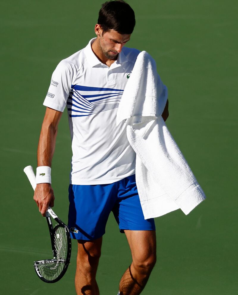 epa07432595 Novak Djokovic of Serbia walks to the chair after breaking his racket on his foot after losing the first set against Philipp Kohlschreiber of Germany during the BNP Paribas Open tennis tournament at the Indian Wells Tennis Garden in Indian Wells, California, USA, 12 March 2019. The men's and women's final will be played, 17 March 2019.  EPA/LARRY W. SMITH