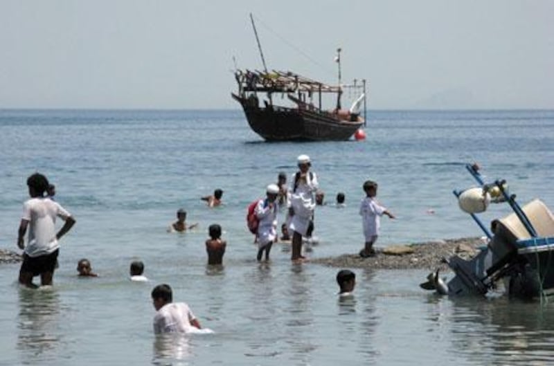 The isolated fishing village of Kumzar on the Musandam Peninsula in northern Oman. Schoolboys play in the sea after their morning lessons.