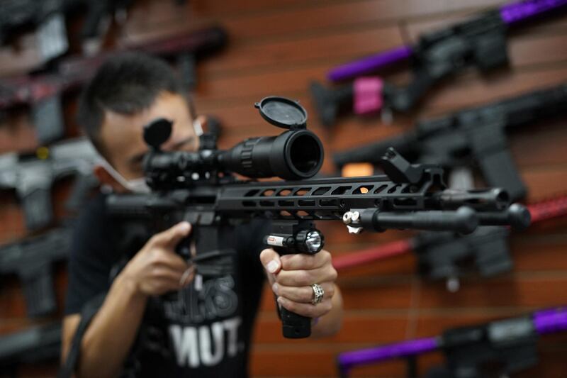 Tom Cai shows off a long gun at Jimmy's Sport Shop in Mineola, New York on September 25, 2020. - Gun store owners on Long Island have been selling out of firearms as scores of customers fear a rise in violence as the pandemic escalates in the area. (Photo by TIMOTHY A. CLARY / AFP)