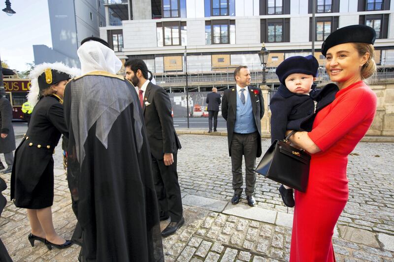 His Excellency Mansoor Abdulhoul following his visit with Her Majesty The Queen at Buckingham Pallace for the presentation of diplomatic credentials. Seen here with his wife in red with black hat, Victoria Devin and the deputy Marshal of the Diplomatic Core with feathers in hat. Outside the Lanesborough Hotel in central London where the reception HE Mansoor Abdulhoul's in D'honneur took place.