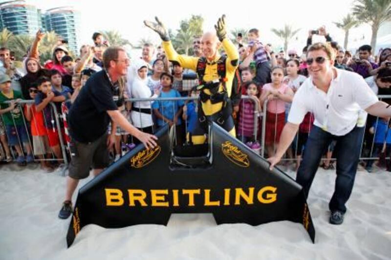 November 19. Yves Rossy, a Swiss pilot, inventor and aviation enthusiast and the first person to achieve sustained human flight using a jet-powered fixed wing strapped to his back, gestures to his wife after landing next to the corniche having completed a flight as part of the entertainment at the Abu Dhabi Science Festival. November 19, Abu Dhabi, United Arab Emirates (Photo: Antonie Robertson/The National)