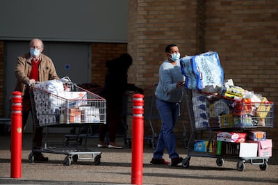 FILE PHOTO: People push full shopping carts outside a store after new nationwide restrictions were announced during the coronavirus disease (COVID-19) outbreak in Watford, Britain, November 2, 2020. REUTERS/Paul Childs/File Photo