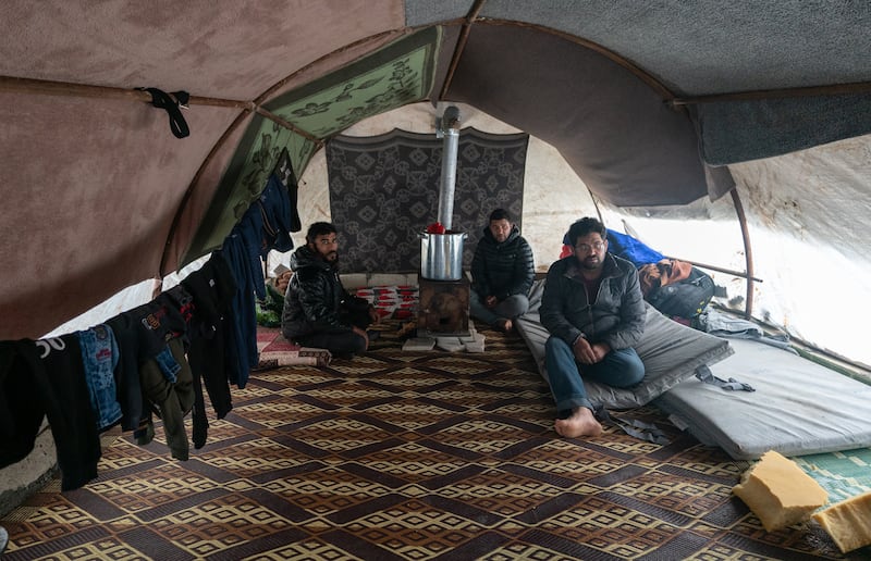 Mr Al Masto with friends in the tent where his family now live. Jindires residents say they desperately need homes, roads, water and a sewerage system