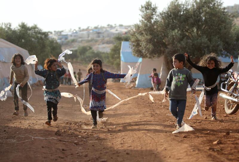 Displaced Syrian children play in a camp for internally displaced people near Kah, in the northern Idlib province near the border with Turkey on June 3, 2019 on the eve of Eid al-Fitr, which marks the end of the Muslim holy fasting month of Ramadan. The conflict in Syria has killed more than 370,000 people and displaced millions since it started in 2011. / AFP / Aaref WATAD
