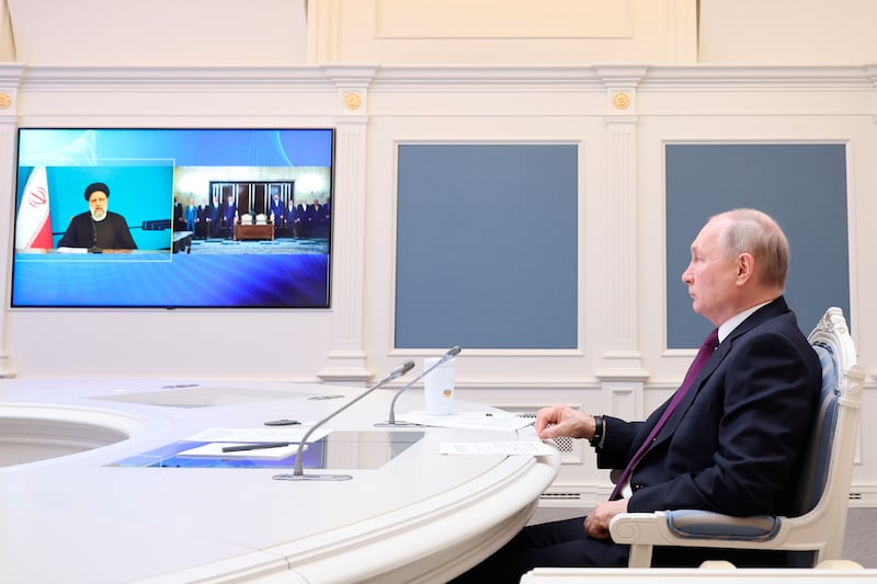 Russian President Vladimir Putin, right, and Iranian leader Ebrahim Raisi witness the signing an agreement on the construction of the Rasht-Astara railway by video on May 17, 2023. AP