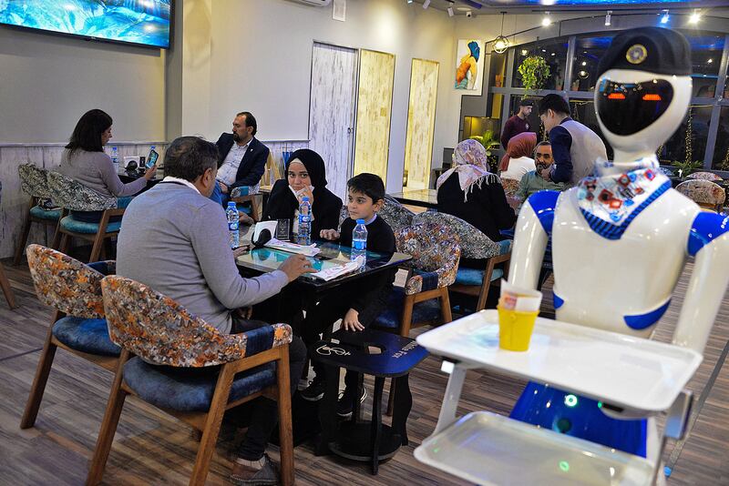 A robot waiter carries a bill to patrons at the White Fox restaurant in Iraq's northern city of Mosul.  All photos: AFP