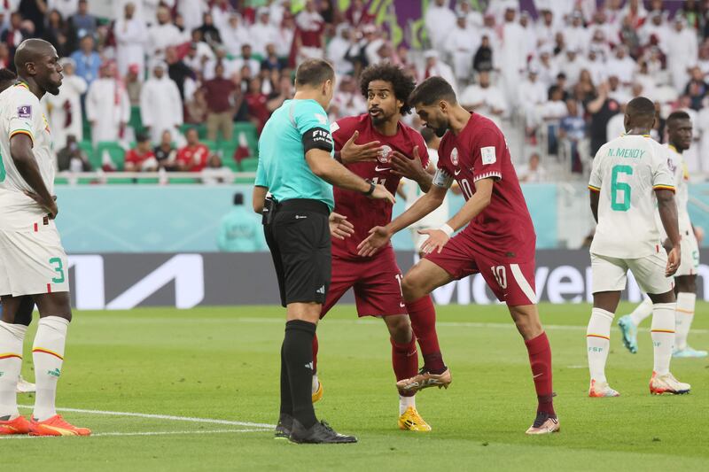 Qatar's Akram Afif and Hassan Al-Haydos appeal for a penalty with Spanish referee Antonio Mateu. AFP