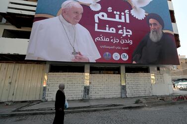 A billboard showing Pope Francis and Grand Ayatollah Ali Al Sistani, with Arabic that reads, "You are a part of us and we are a part of you," hangs on a street in Baghdad, Iraq. AP