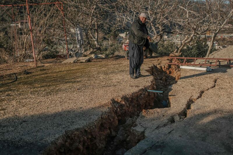 A resident shows the giant cracks next to his home in Nurdagi. AFP