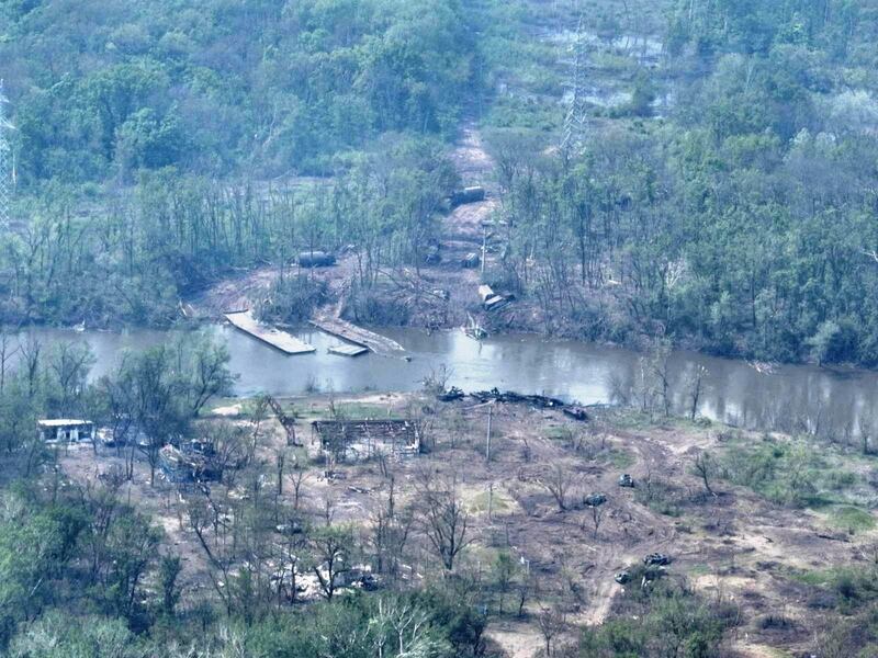 Burnt vehicles and the remains of what appears to be a makeshift bridge across the Siverskyi Donets River in eastern Ukraine. Reuters