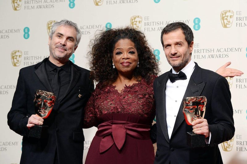 British producer David Heyman, right, and Mexican director Alfonso Cuaron, left, pose in the press room after winning the Outstanding British film award for ‘Gravity’ with the award presenter, US TV host and actress Oprah Winfrey at the 2014 EE British Academy Film Awards ceremony at The Royal Opera House in London. Andy Rain / EPA